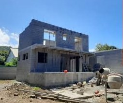Chantier de maison à étage avec bétonnière au premier plan