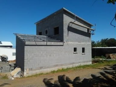 Maison en blocs béton à étage avec charpente en cours de pose