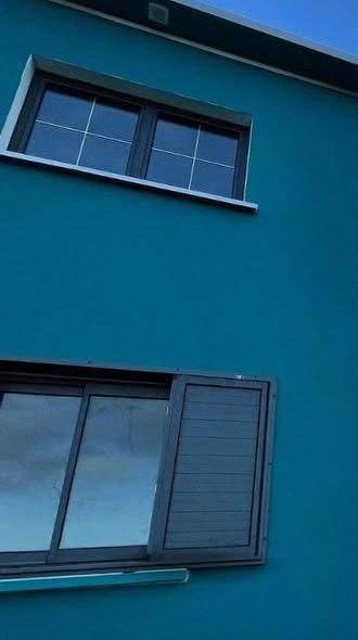 Façade enduite bleu pétrole avec menuiseries aluminium